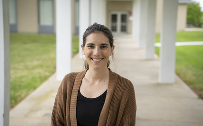 Stephanie Servetas poses smiling outdoors on the NIST Gaithersburg campus.