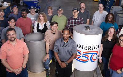 A group of people around a cylindrical time capsule