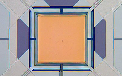Micrograph of yellow square with lines attached to each corner.