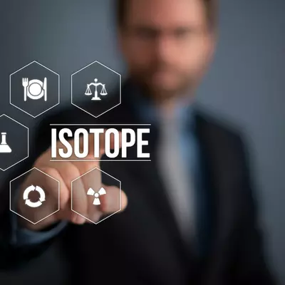 Figure with the word “isotope” and related icons superimposed on a photograph of a man pointing to the figure. 
