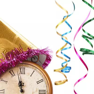 Stock image of old analog watch wearing party hat with ribbons nearby