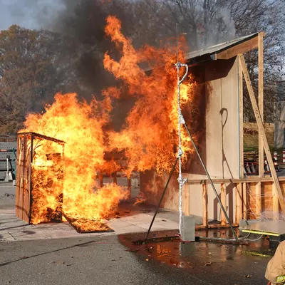 Researchers burn a shed to measure the fire exposure to a nearby residential façade to determine safe separation distance and test WUI fire building code requirements.