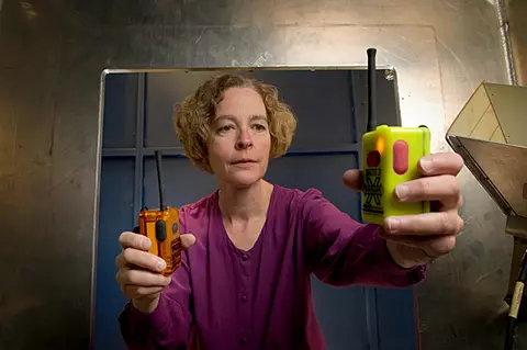 NIST engineer Kate Remley holds two Personal Alert Safety System (PASS) devices with wireless alarm capability. 