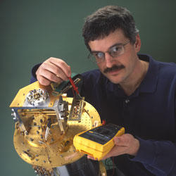 Project leader Kent Irwin installs superconducting materials in an ultra-cold refrigerator for testing. 