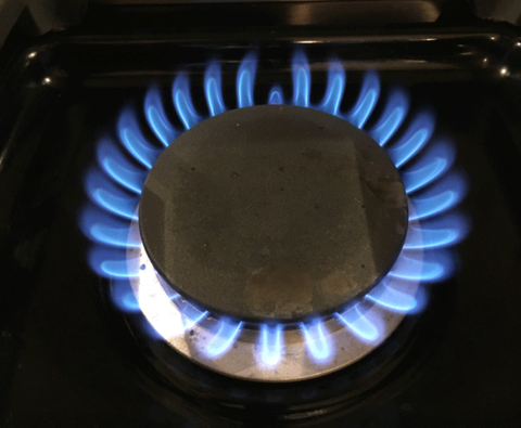A stove burner showing a natural gas flame