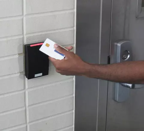Photo of a person holding a PIV card up to a reader