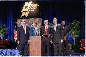 (Left to right) Commerce Secretary Don Evans; Karen Hollingsworth, vice president, First in Service Performance Excellence, Clarke American Checks; Charles Korbell, president and CEO, Clarke American Checks; President Bush; Education Secretary Rod Paige.