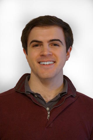  Joshua Taillon, a person with short brown hair, smiling for the camera. 