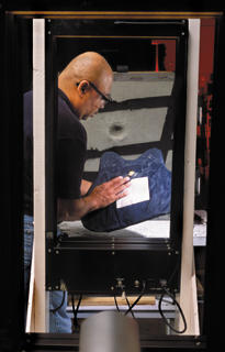 NIST engineering technician Nathaniel Waters examines a bullet-resistant vest being tested