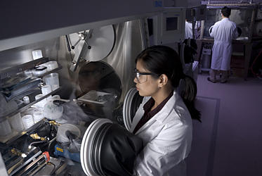 NIST researcher Leah Lucas examines thin film transistors made on plastic rather than silicon using a protective glove box.