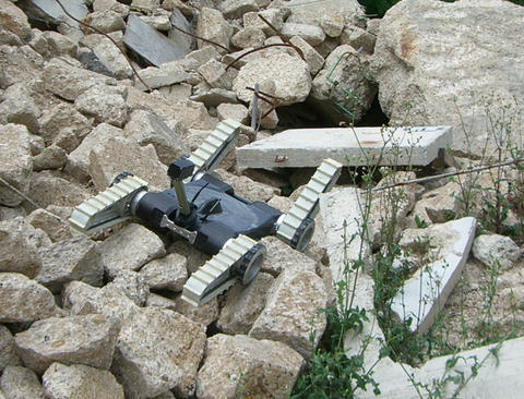An urban search and rescue robot moves across a rubble pile