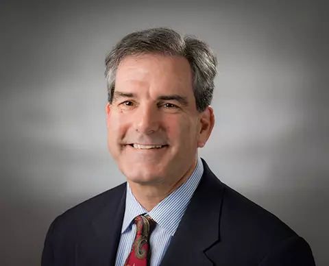 Professional headshot of Steve Choquette, a man with short gray hair, smiling, wearing a suit and tie.