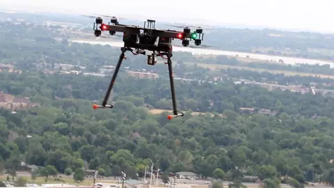 Quadcopter flying in the air over trees