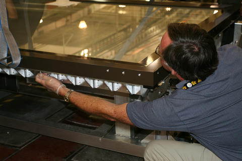 NIST technician putting bolts into the map encasement