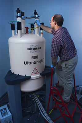 NIST research chemist John Marino places a RNA sample into the magnet of a nuclear magnetic resonance instrument