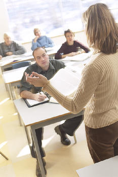 A photo of a woman teaching a classroom of adult students
