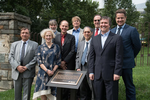 Various NIST employees with the posing with plaque commemorating the invention of the atomic clock on the campus of what is now the University of the District of Columbia