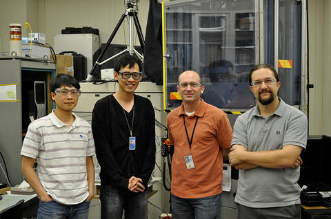 Four men stand looking at the camera