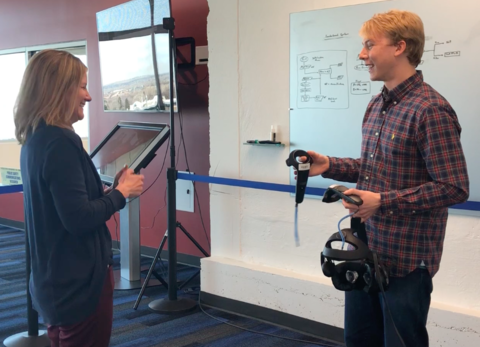 Jack Lewis is showing Sandra Wendelken how to use VR