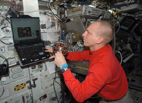 Astronaut aboard the International Space Station is seen preparing a carousel holding samples of materials for a smoke detection test.