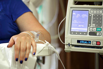 Person seated with IV from arm to machine.