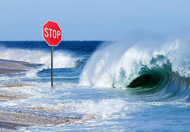 wave crashing over stop sign