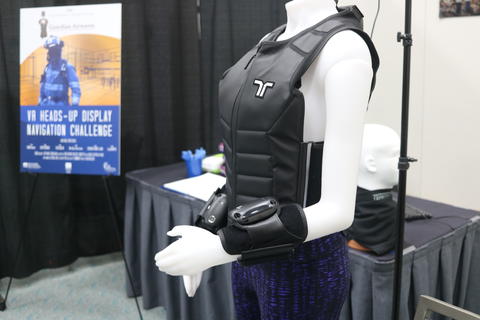 A vest lies on a mannequin next to a prize competitor's demonstration for their Virtual Reality prototype for the Virtual Reality Heads up Display Prize Challenge.