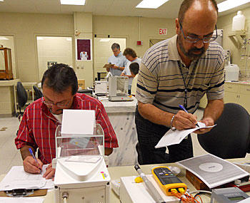 Instructors perform measurements during dry run of Fundamentals of Metrology course