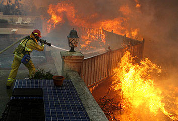 Firefighter spraying flames with hose