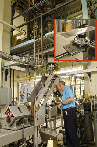 Fred Bateman stands by the platform of the electron-beam test apparatus.