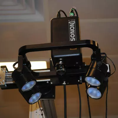 A hyperspectral line camera with four broadband light sources acquires images with the lens at center.