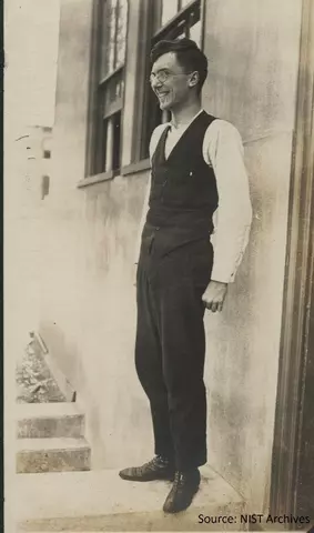 man in a suit standing by a building