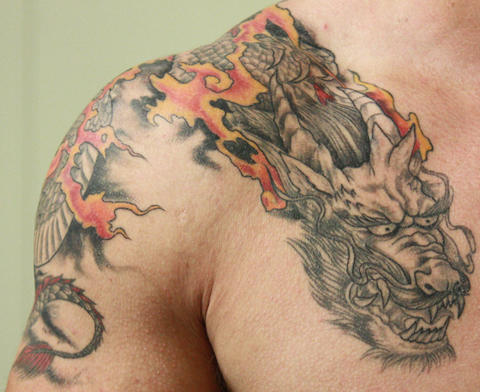 man's shoulder with a dragon tattoo