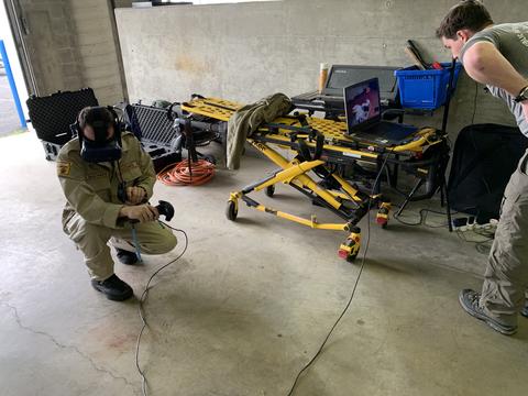 First responder using virtual reality with an EMT stretcher in the background.
