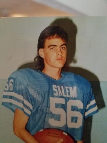 young man in a football uniform with a football under his arm