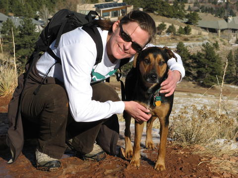 Tara crouching down beside her dog