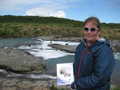 Maureen Washburn in outdoor setting with a few bears in the distant background