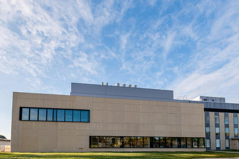 A large tan building with blue sky in the background.