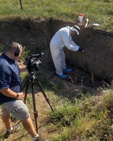FBI Gelogist-Forensic Examiner and videographer in a soil pit.