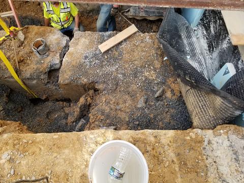 photo of construction crew with excavated pipes that are broken.