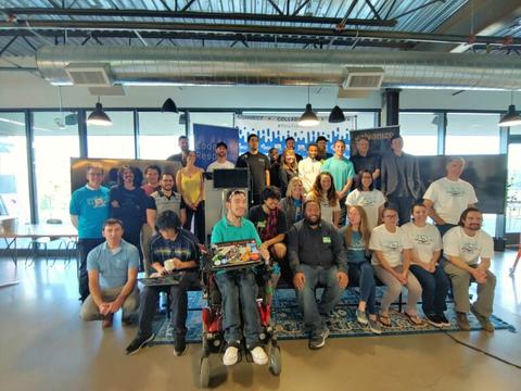 This image shows teams of people, some with laptops, standing in front of Tech to Protect challenge signs.