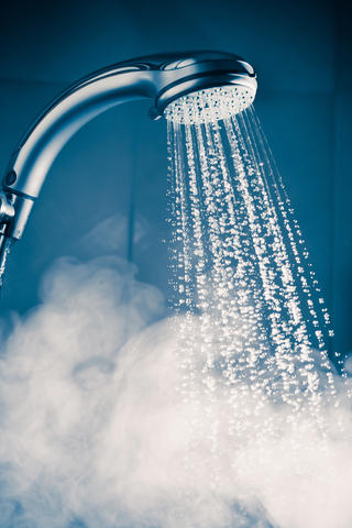 A shower head with steamy water coming out.