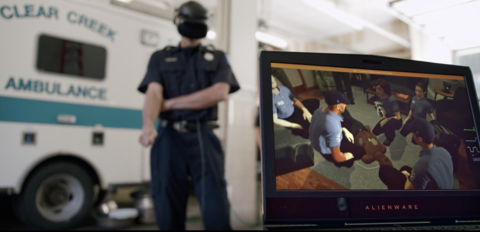 This image shows an EMT standing in front of an ambulance with a VR headset on. In front of him is a laptop depicting the virtual scenario.