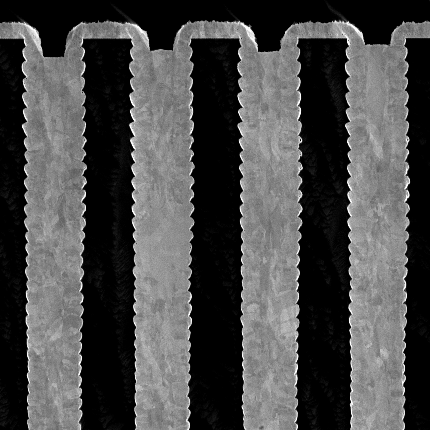 New metal-filling method for phase contrast x-ray imaging Micrograph shows several connected trenches of metal on dark background.