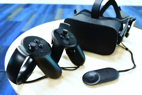 This image shows a virtual reality headset and hand controllers on a white table