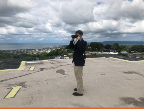 NIST research structural engineer Joe Main on the roof of the Hospital Bella Vista in Mayaguez, Puerto Rico in 2017. Joe is photographing the surrounding terrain to document local topography and surface roughness.