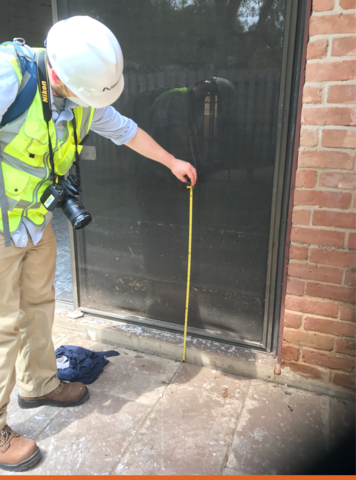 Travis Thonstad of the NIST Materials and Structural Systems Division measuring a high-water mark on a Houston, Texas residence after Hurricane Harvey in 2017.
