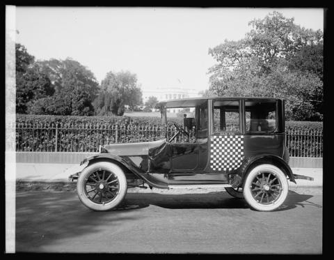 Checker cab, White House in background; Washington, D.C.