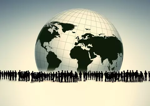 Shadows of all types of people, all genders and ages, standing from left to right in the middle of the frame. In the background, a globe showing, in black, the continents of North and South America, Africa, Europe, and Asia. 