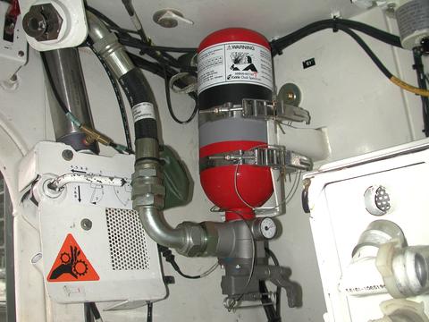Fire extinguishing system in armored ground vehicle Red fire extinguisher is attached to pipes and hoses inside a vehicle.